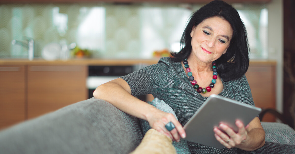 woman sitting on couch using tablet Thumbnail
