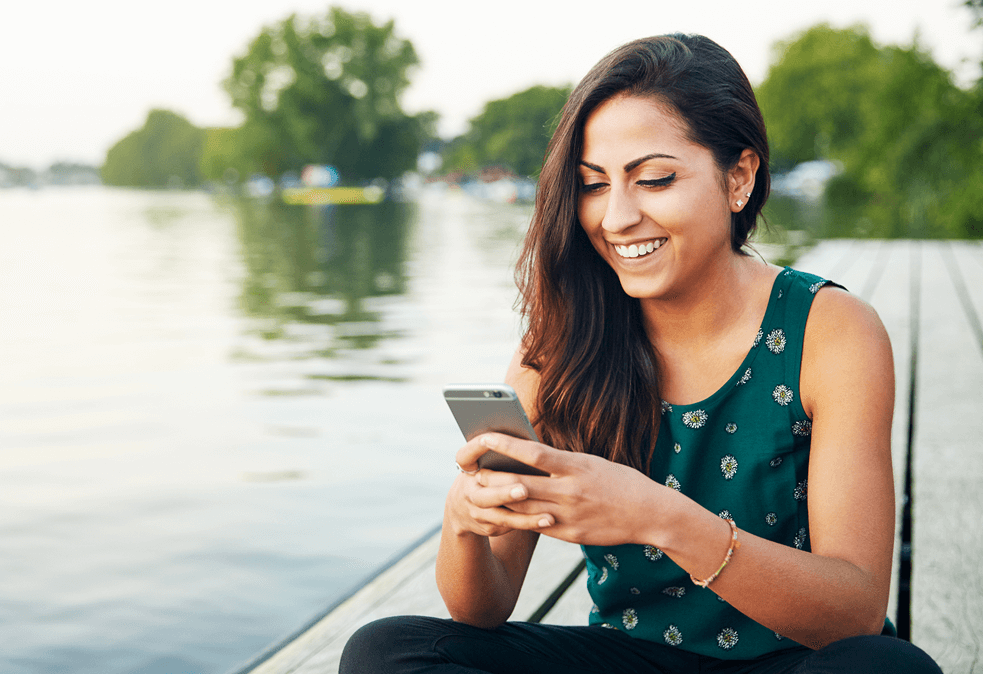 woman using cell phone on a pier