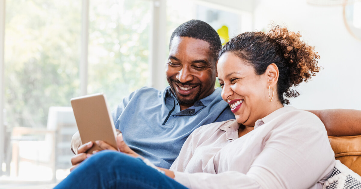 couple in living room looking tablet