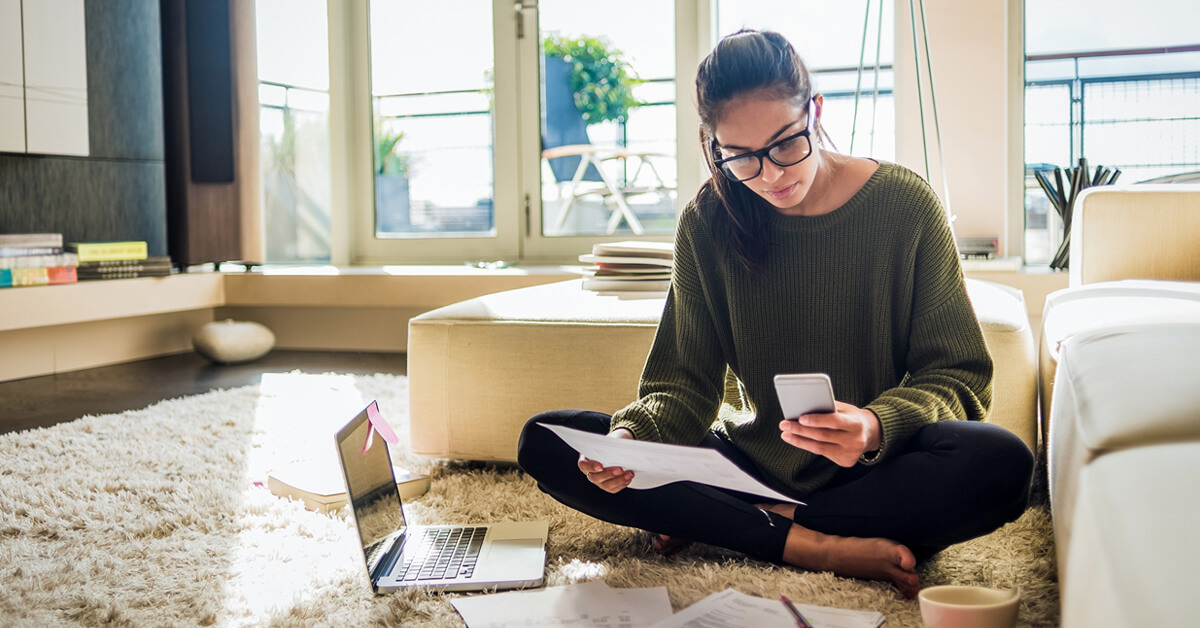 woman reviewing finances from home using mobile app and online banking Thumbnail