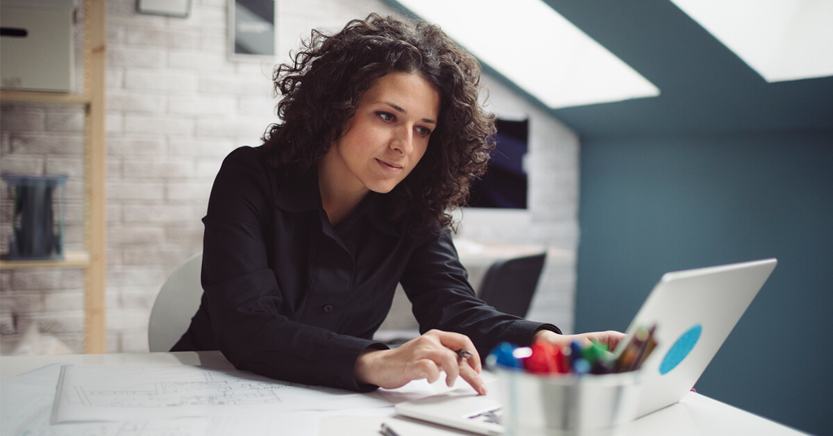 woman in studio checking finances on laptop Thumbnail